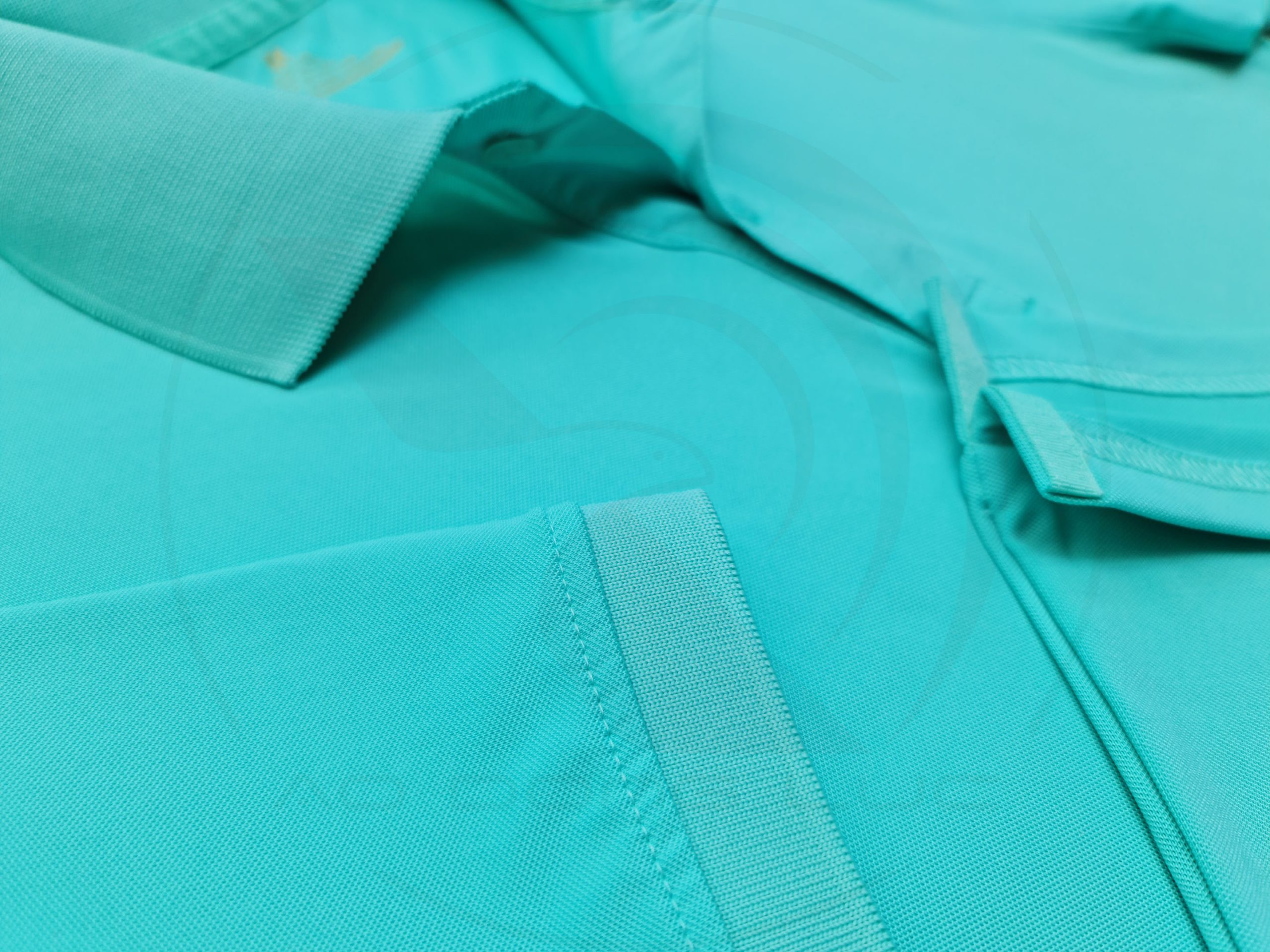Chi tiết đường may và vạt áo áo thun cổ trụ polo bo trơn cá sấu lạnh xanh ngọc