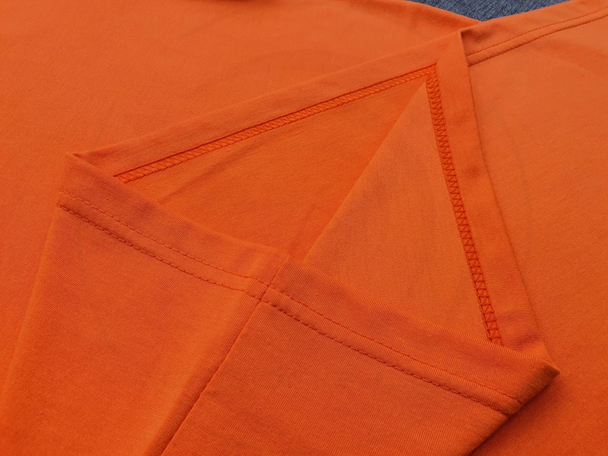 Hình chi tiết đường may và vạt áo áo thun cổ tròn ngắn tay unisex màu cam